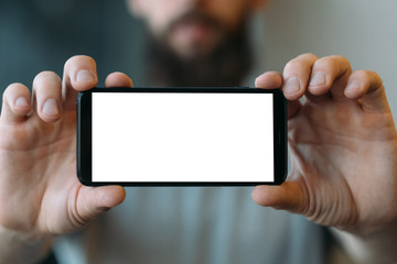 Mobile application. Closeup of white mockup smartphone screen in man hands. Copy space.