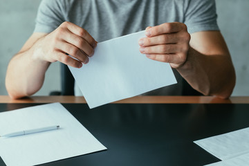Written communication. Cropped shot of man folding blank mockup letter to send. Copy space.