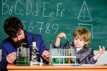 Knowledge is delicious. school kid scientist studying science. teacher man with little boy. Back to school. father and son at school. Little kid learning chemistry in school laboratory