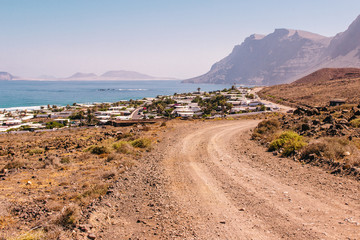 camino de tierra con vistas al Risco de Famara en la isla de Lanzarote
