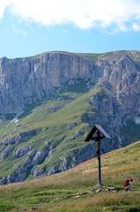 Wooden crucifix in a meadow mountain