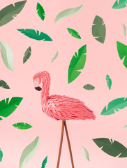 Pink paper flamingo on pink background with green leaves texture. Creative summer concept. Minimal art.
