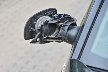 Road accident.  Black car with a broken side mirror. Crushed automobile side view mirror. Parked auto with breakdown glass. Car vandalism. 