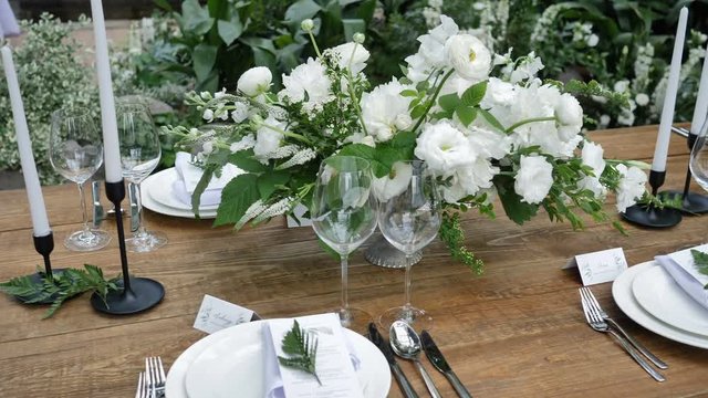 Beautiful Decor of an old wooden table for a wedding evening in rustic style with floral bouquets and candles
