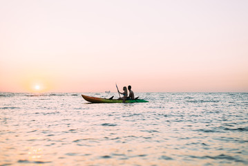 kayaks active lifestyle, a couple in love man and woman meet the dawn on the ocean