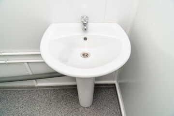 White clean sink with the crane in the bathroom