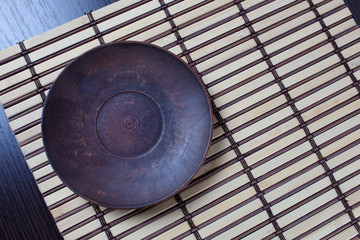 Empty clean pottery bowl on a bamboo mat.Copy space