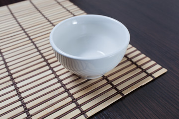 Empty clean bowl on a bamboo mat.Copy space