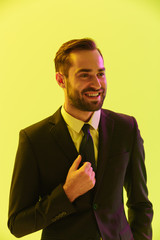 Image of joyful young businessman in formal suit smiling at camera