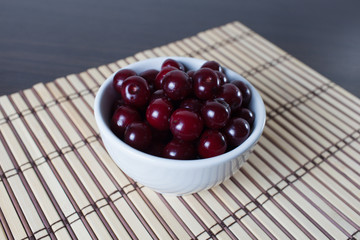 Bowl of сherries on a bamboo mat.Copy space