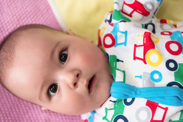 top view of newborn baby boy lying on colorful blankets