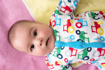 top view of newborn baby boy lying on colorful blankets