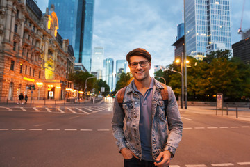 Obraz premium Attractive young man walking at the city streets in the evening
