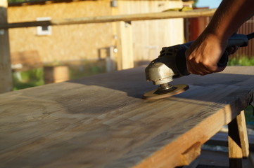carpenter cutting plank with saw