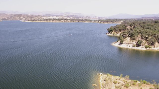 Aerial Drone Tracking Shot of a Boat on a Mountain Lake (Cachuma Lake, California)
