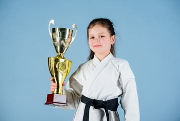 winner little girl in gi sportswear. practicing Kung Fu. happy childhood. sport success in single...