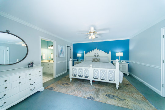 Blue and White Modern Bedroom with King Sized White Wood bed and accent table lamps