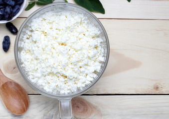 Simple rustic breakfast of honeysuckle berries and fresh cottage cheese, top view.Background from a...