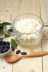 Simple rustic breakfast of honeysuckle berries and fresh cottage cheese, top view.Background from a...