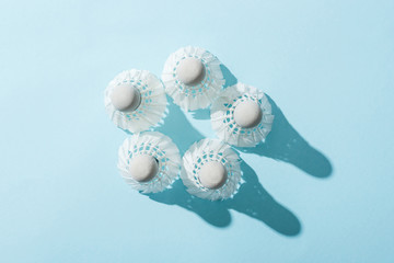 top view of shuttlecocks with white feathers on blue