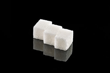 sugar cubes on a black mirror background