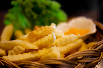 Tasty french fries and ketchup on wooden table background