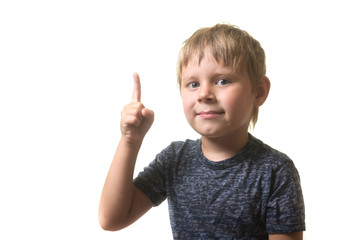 Portrait of a little boy excited with an idea. A boy holds his index finger up isolated on a white background.