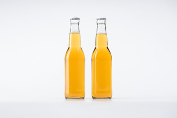 glass bottles of beer in row on white background