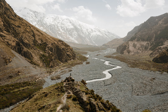 Amazing view alongside Georgian military road, high in the Caucasus mountains. Winter time, high mountain peaks covered with snow. Wooden cross beside the road.