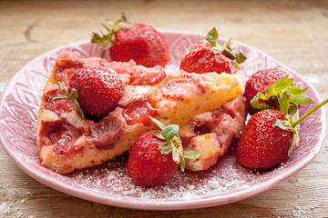 Piece of round strawberry berries tart pie pudding on pink plate on rustic wooden background
