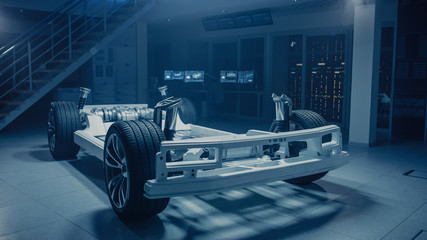 Concept of Authentic Electric Car Platform Chassis Prototype Standing in Industrial Machinery...