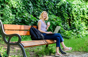 Obraz premium girl work on laptop. modern woman with computer outdoor. summer online. Morning chart. girl drink coffee to go. Relax in park. Pretty woman drinking takeaway coffee. Smart and confident student