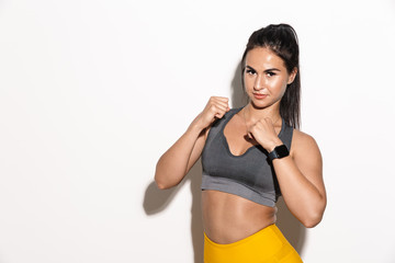 Fototapeta na wymiar Beautiful amazing young sports fitness woman boxer isolated over white wall background posing.
