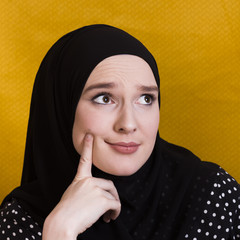 Doubtful woman thinking something with finger on her cheek