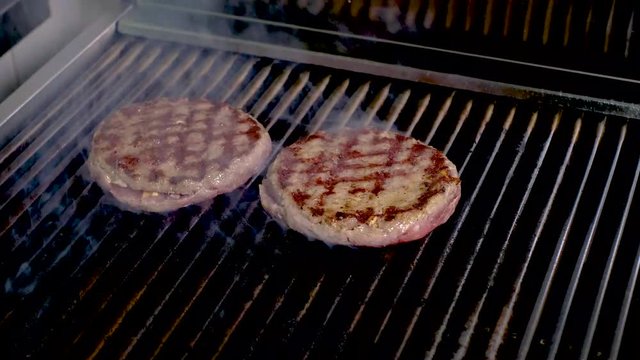 Preparing a batch of ground beef patties or frikadeller on grill or BBQ