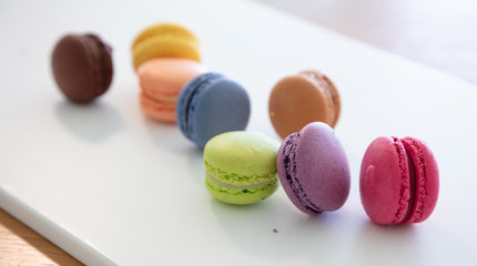 Colorful macarons on white background, close up view