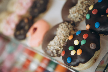 Display of delicious pastries in a bakery shop with assorted glazed donuts , biscuits and cookies on trays in a shop counter
