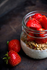 Healthy breakfast with yogurt, muesli and red ripe strawberry. Selective focus. Shallocw depth of field.