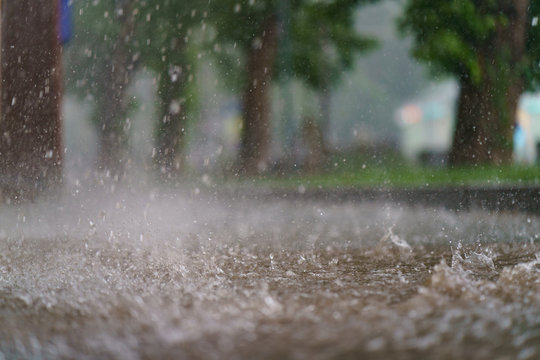 Raining Day In The City At Summer Time. Texture Of Strong, Fresh And Powerful Water Drops And Sprays. Puddle With Ripple On Mocow Road. Power, Energy In Nature