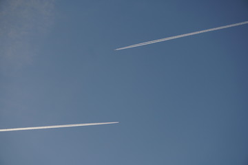 estelas blancas de aviones en sentido opuesto sobre cielo azul