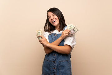 Young Mexican woman over isolated background taking a lot of money