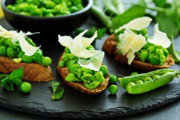 Crostini with pea puree, mint and parmesan. Snack.