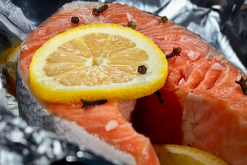 Salmon steak with lemon, fish fillet, cooked for baking in foil. Close up.