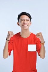 Young asian man happy and excited expressing winning gesture. Successful and celebrating