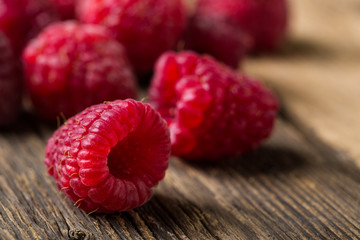 Fresh raspberries on wooden table close-up