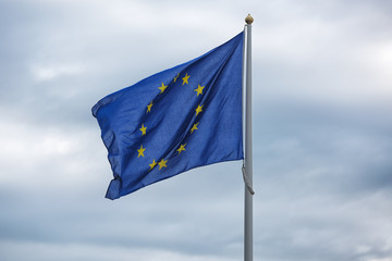 Flags of EU on blue sky. Concepts of politics, tourism, economy, cooperation, eurozone and other.