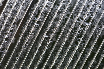 Water droplets on cellular polycarbonate, pattern and structure with variable scale and direction.