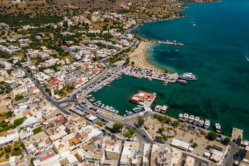 Fototapeta na wymiar ELOUNDA, CRETE, GREECE - JULY 16 2019: Aerial view of the popular high-end tourist town of Elounda on the Greek island of Crete in the Aegean Sea.