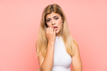 Teenager girl over isolated pink background nervous and scared