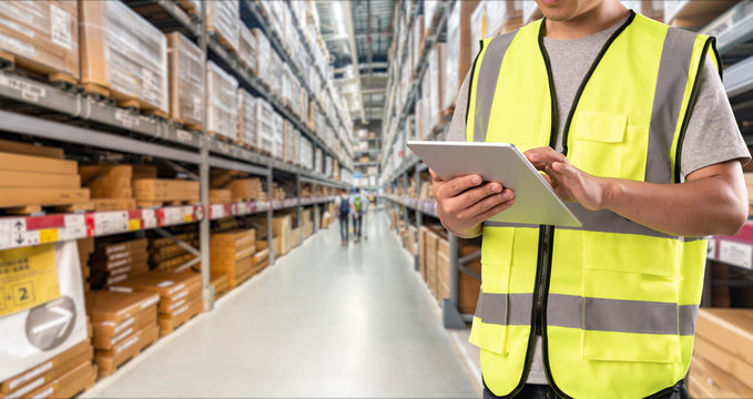 worker hand holding pad for check order pick time in smart factory warehouse